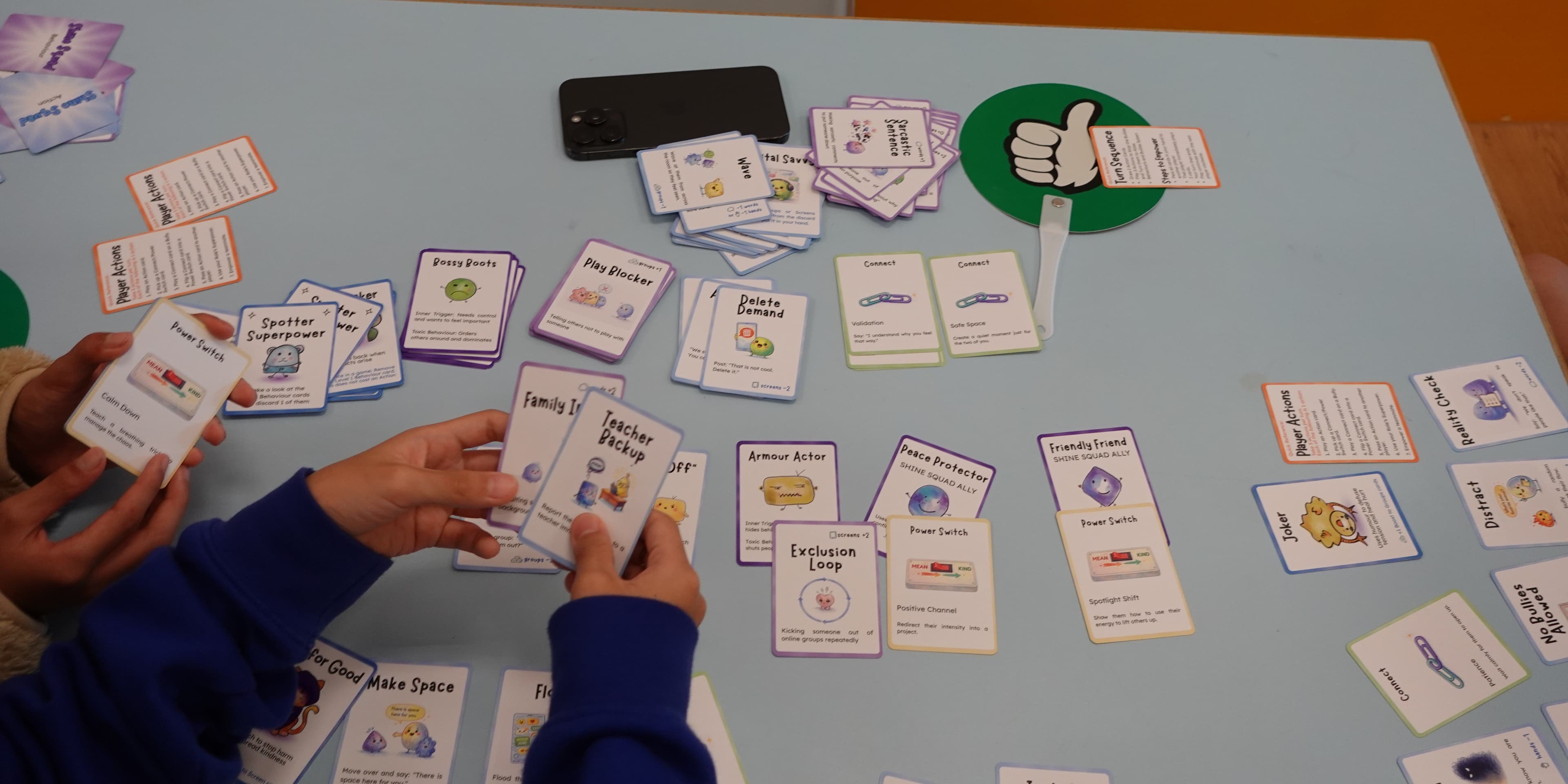 Kids playing the Shine Squad card game around a table